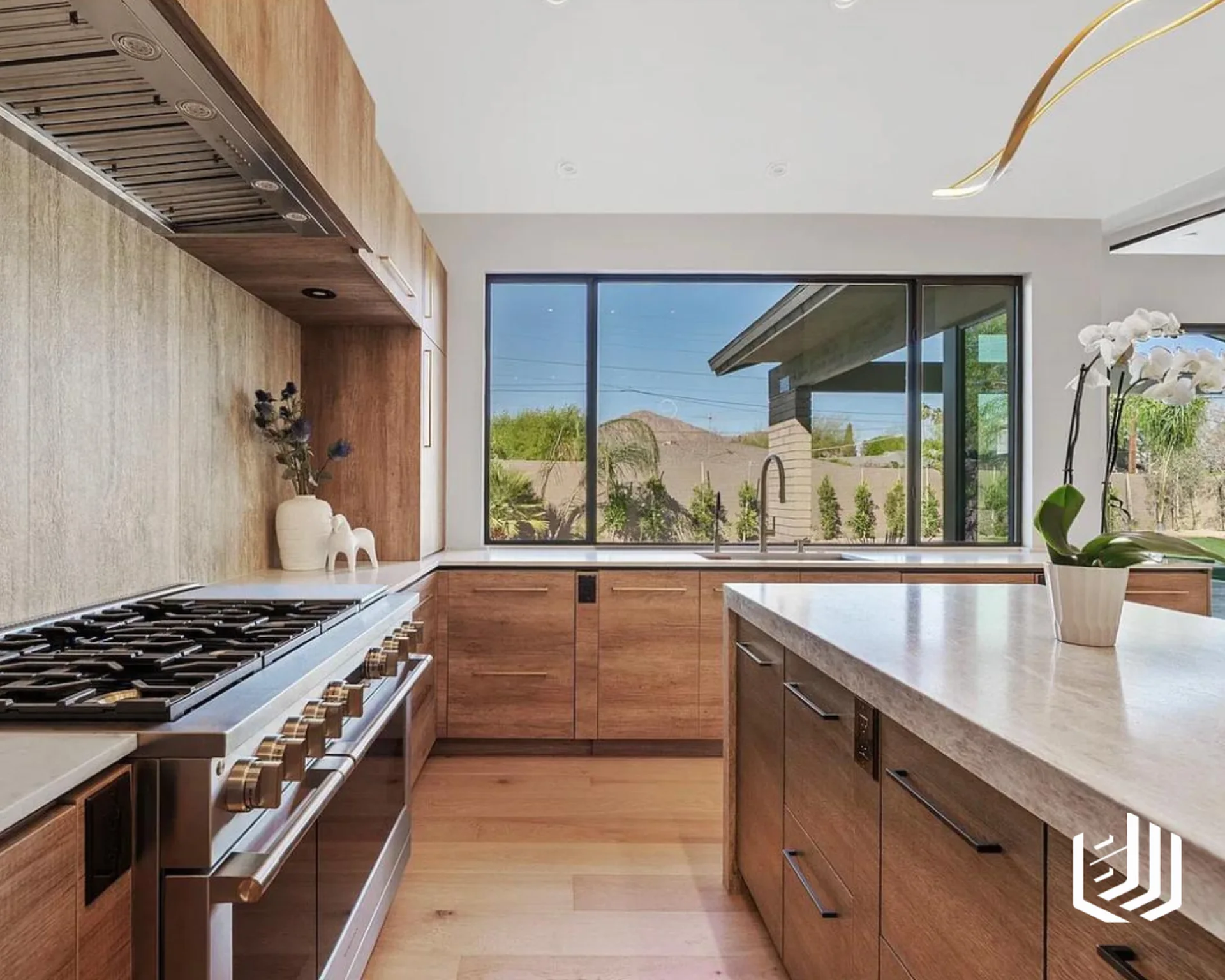 Light wood kitchen with a range wall, long windows and a stone island