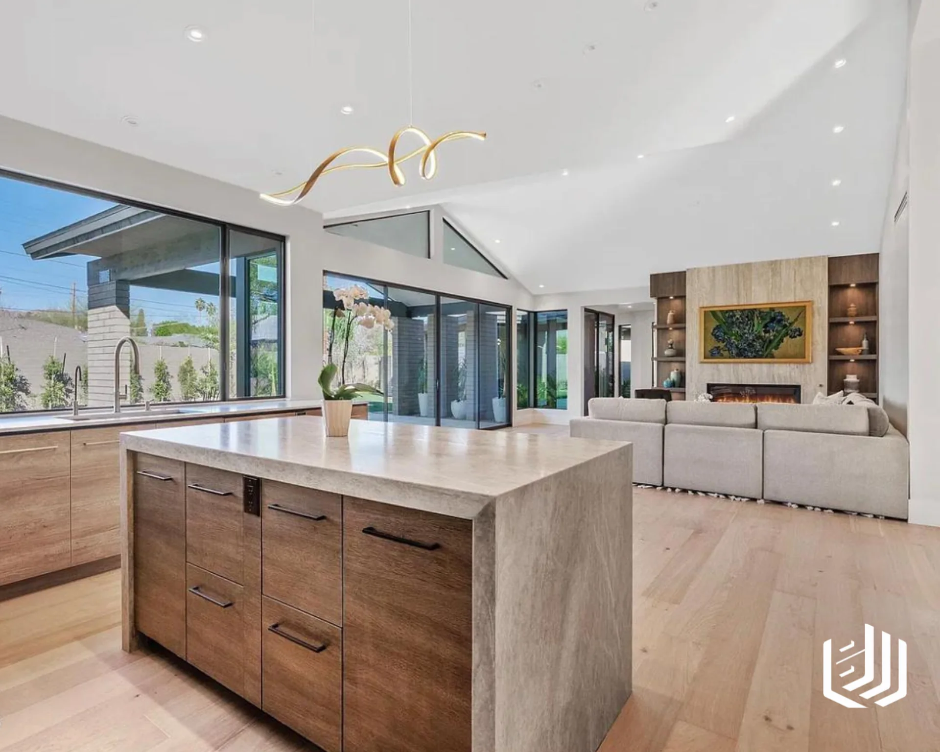 Wood kitchen island with a stone waterfall end overlooking an open living room