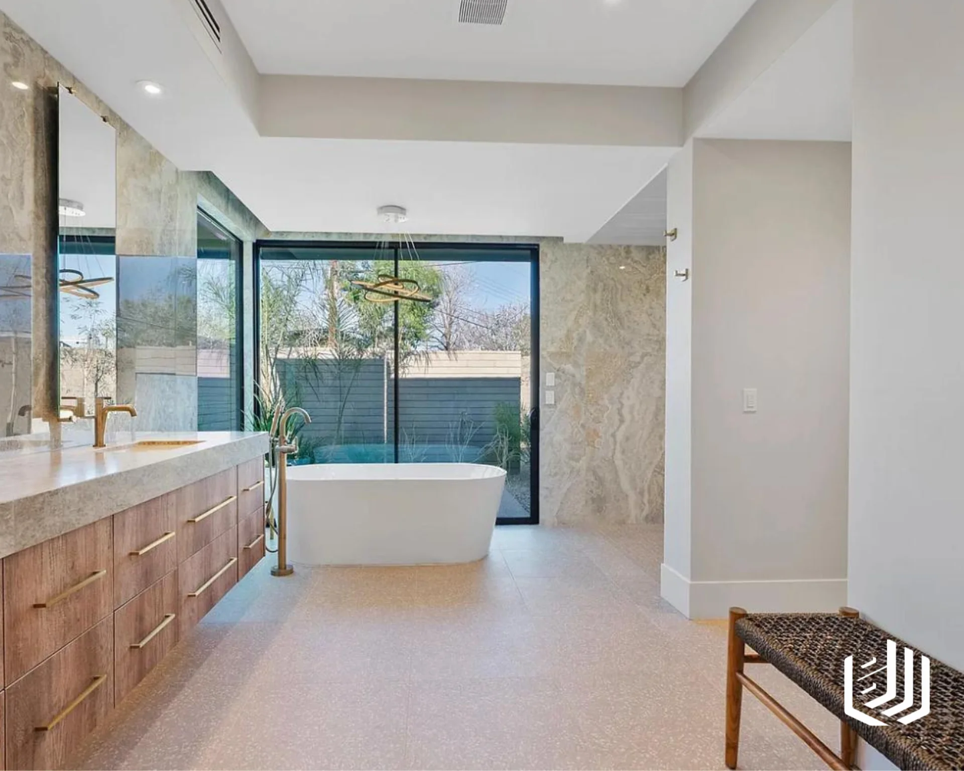 Bright bathroom with a wood vanity, freestanding tub and large garden windows