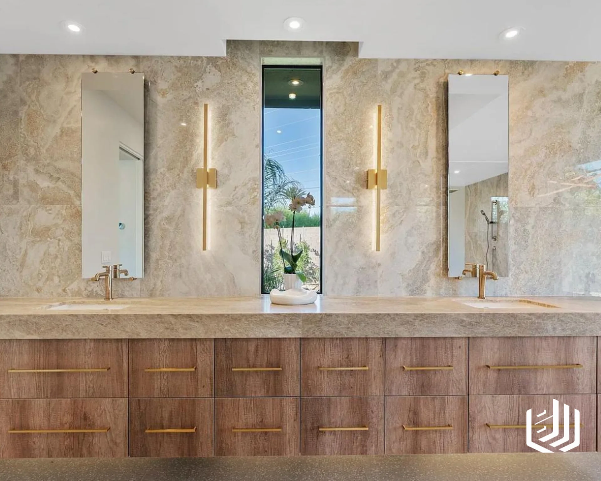 Double vanity with a stone counter and backsplash above wood drawers